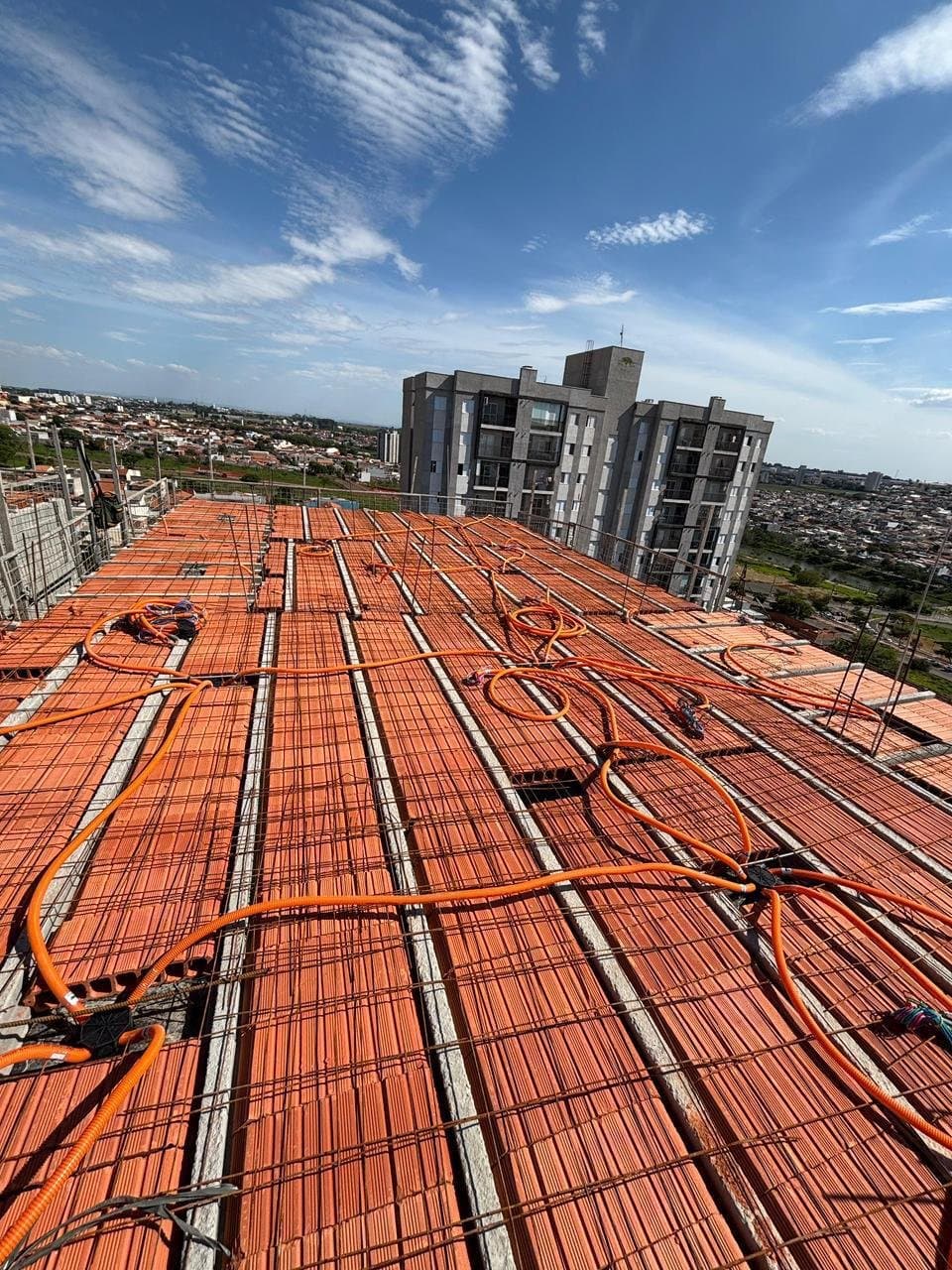 Laje de uma torre antes da concretagem, com eletroduto laranja da Polvolt já distribuído sobre a armadura e as caixas posicionadas